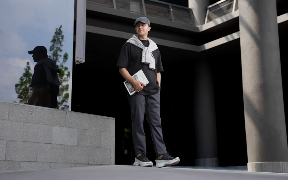 Inspirasi office look santai memadukan kaos oversize hitam rapi yang dimasukkan sebagian (french tuck) ke dalam celana Maaz Ankle Pants Fadkhera.